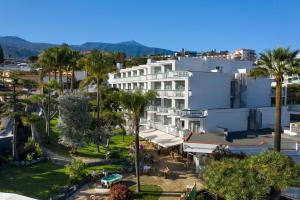 拉克鲁斯派克度假艾顿酒店的一座拥有棕榈树的白色建筑