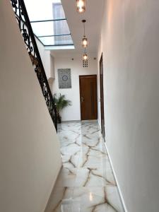 拉巴特Riad Jbara 2的走廊上设有白色墙壁,楼梯上设有大理石地板