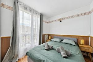 奥贝维利埃Appartement F3 15 mins à Paris的一间卧室设有一张绿色的床和大窗户
