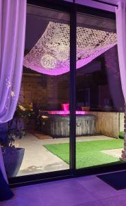 AwoingtGARY Suite - Studio Cosy, Spa et jardin privatif à 4 min de Cambrai的紫色灯光和花园美景窗户