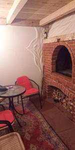 库普雷斯Chalet Katy的客房设有砖砌壁炉、桌子和椅子
