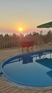 费特希耶Esila bungalow sea and nature wiev的一个带长凳的游泳池,享有日落美景