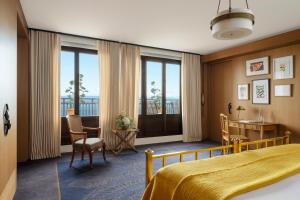 埃维昂莱班罗亚酒店的酒店客房,配有一张床、一张桌子和椅子