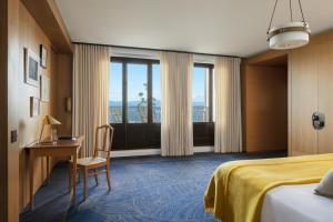 埃维昂莱班罗亚酒店的配有一张床、一张书桌和一扇窗户的酒店客房