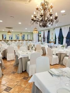 克雷维连特拉斯棕榈露营酒店的一间配备有白色桌椅和吊灯的餐厅