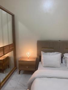 努瓦克肖特Nouakchott INN的一间卧室配有一张床和一张带心灯的桌子
