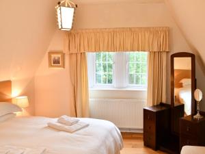 MayboleCloncaird Castle Estate Cottages的卧室配有白色的床和窗户。