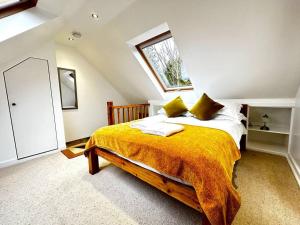 牛津Dove House Cottages - No 1的一间卧室配有一张带黄色毯子的大床