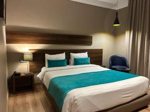 卡萨布兰卡Yto boutique Hotel的一间卧室配有一张带蓝色枕头的大床