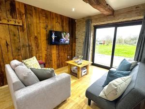 牛津Dove House Cottages - No 1的客厅配有两张沙发和一台电视机