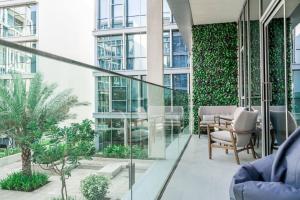 迪拜HiGuests - Magnificent Apt with Panoramic Views All Around的大楼内的阳台配有椅子和植物