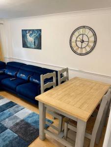 沃特福德Spacious 5 Bedroom House- Harry potter world & London的客厅配有桌子和蓝色沙发
