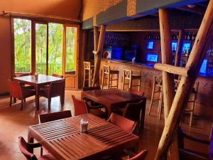 Marangu巴比伦旅馆 的一间带桌椅的餐厅和一间酒吧
