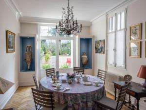 奥尔良Room in Guest room - This 10th Century home sits in an extraordinary setting in the center of Orleans的一间带桌椅和吊灯的用餐室