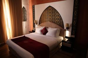 丹吉尔明萨酒店的一间卧室配有一张大床和大床头板