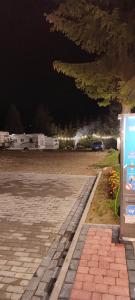 布科维纳-塔钱斯卡Tatrzański Camper Park- parcele kamperowe的夜间停在停车场的公共汽车
