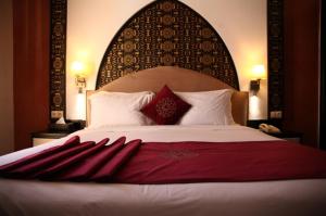丹吉尔明萨酒店的一间卧室配有一张大床和大床头板
