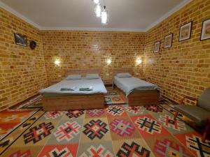 撒马尔罕MUSAVVIR的一间设有两张床和砖墙的房间