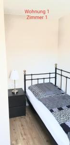 锡根2x Monteurwohnung 1x 2 kleine Einzelzimmer 1x Doppelbett und Schlafcouch im Wohnbereich的一间卧室配有一张床和一张带台灯的桌子