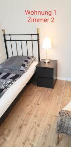 锡根2x Monteurwohnung 1x 2 kleine Einzelzimmer 1x Doppelbett und Schlafcouch im Wohnbereich的一间卧室配有一张床和一张带台灯的桌子