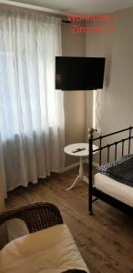 锡根2x Monteurwohnung 1x 2 kleine Einzelzimmer 1x Doppelbett und Schlafcouch im Wohnbereich的客房设有两张床、一张桌子和一扇窗户。