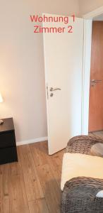 锡根2x Monteurwohnung 1x 2 kleine Einzelzimmer 1x Doppelbett und Schlafcouch im Wohnbereich的一间设有两张床和白色门的房间
