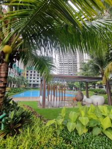 TjilandakMashley Room Prestige Apartment SKY HOUSE BSD的享有带游泳池和棕榈树的度假村的景致