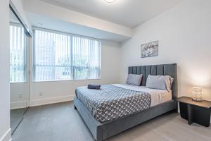 多伦多Luxury Properties in Toronto Downtown Core的一间卧室设有一张大床和两个窗户。