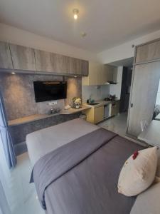TjilandakMashley Room Prestige Apartment SKY HOUSE BSD的一间带大床的卧室和一间厨房