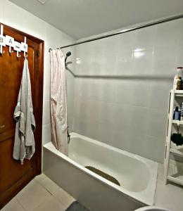 阿雷西费Amanecer Isleño Habitaciones的带淋浴的浴室配有白色浴缸。