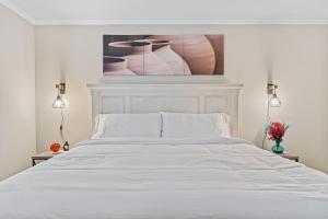 亚特兰大W - Atlanta Luxury 1bdr 1bath ensuite shared Condo in prime location的卧室配有一张白色床,墙上挂有绘画作品