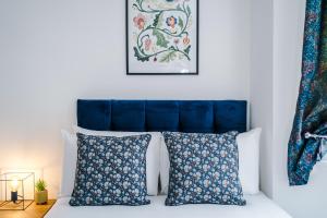 考文垂The Consort Serviced Apartment Coventry的一间卧室配有蓝色床头板和两个枕头