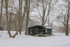 塔尔西Dunduriņi的雪覆盖的森林中的黑色小小屋