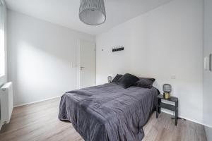 雷克雅未克Glacial Properties, Cozy apartment in Kópavogur的白色卧室,配有一张带灰色毯子的床