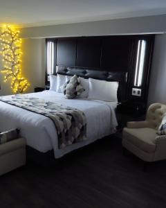 迪格比码头边套房宾馆的一间卧室配有一张大床和一把椅子
