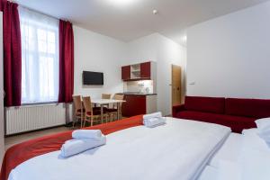 亚希莫夫Hotel Dagmar的酒店客房带两张床和一张红色沙发
