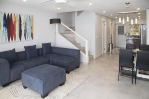 Jolly Harbour246C, South Finger, Waterfront的客厅设有蓝色的沙发和楼梯。