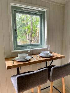 UplymeCosy Shepherds Hut Lyme Regis的一张带两把椅子的木桌和窗户