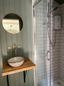 UplymeCosy Shepherds Hut Lyme Regis的一间带水槽、镜子和淋浴的浴室
