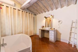 基安蒂盖奥勒博尔戈卡萨尔文托酒店的带浴缸、水槽和镜子的浴室