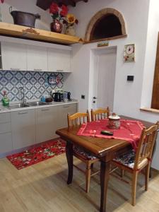拉迪科法尼La Casa di Olga的带木桌和椅子的厨房以及带水槽的厨房。