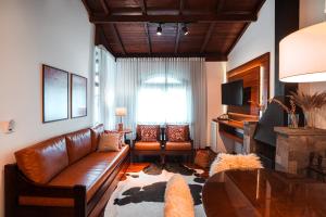 卡内拉苏珊娜维拉公园酒店的客厅配有真皮沙发和桌子