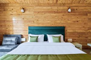 丹德利Stone Wood Jungle Resort, Dandeli的一间卧室设有一张大床和木墙