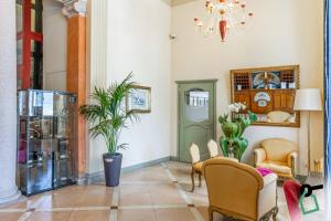 韦尔巴尼亚HOTIDAY Hotel Verbania的客厅配有椅子和盆栽植物