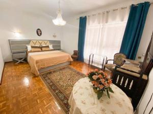 GH Odivelas - Quartos em Casa com Bilhar!的卧室配有1张床、1张桌子和1把椅子