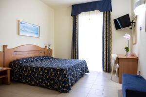 圣伊西多罗萨兰托村蓝色酒店的一间卧室设有一张床和一个大窗户