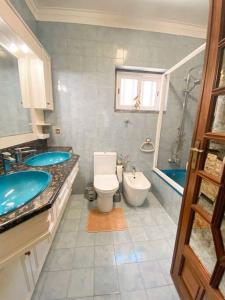 GH Odivelas - Quartos em Casa com Bilhar!的浴室配有2个盥洗盆、卫生间和浴缸。