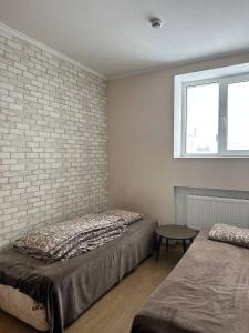 科韦利Apartment的一间卧室设有两张床和砖墙