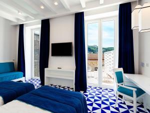 索伦托Maison Blu - Intimate GuestHouse的一间酒店客房,设有两张床和电视