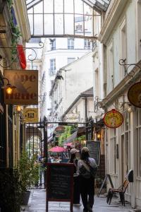 巴黎Hôtel Saint-André des Arts的走在狭窄街道上,有建筑的人